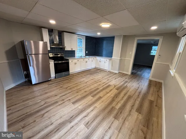 a kitchen with stainless steel appliances kitchen island granite countertop a refrigerator and a sink