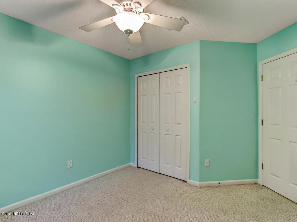 573 Prosperity Lake Drive St. Augustine, FL 32092 - Photo 14 of 23 an empty room with a chandelier fan and a chandelier fan