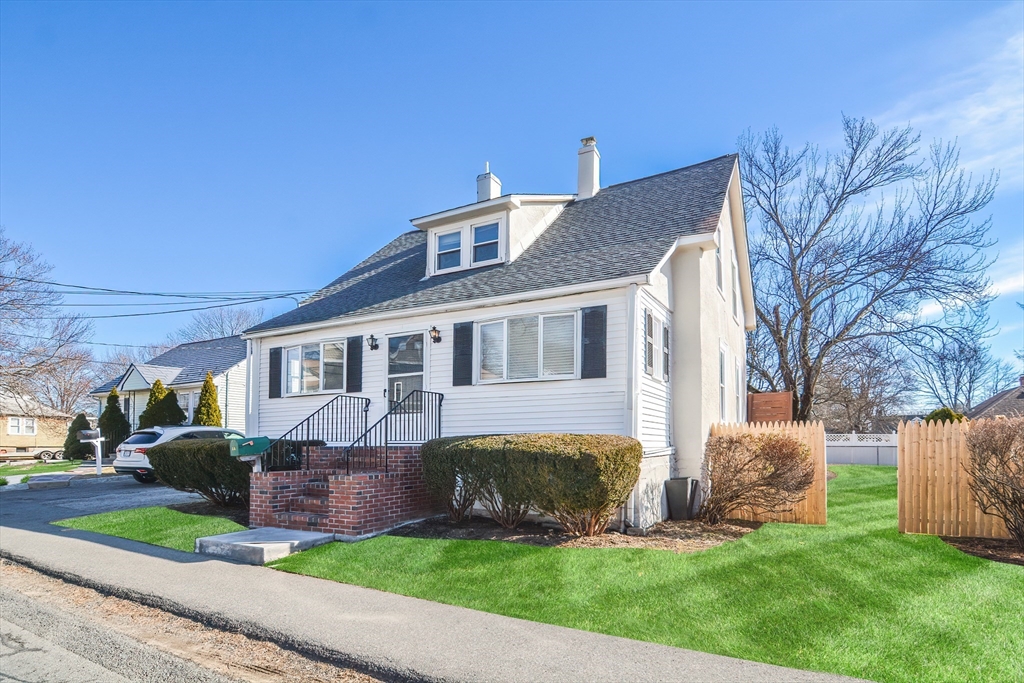 58 Holmes Road Dedham, MA 02026 - Photo 2 of 29 a front view of a house with a garden and trees