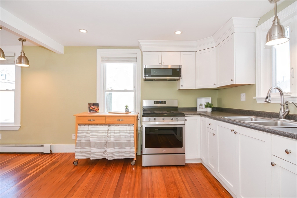 58 Holmes Road Dedham, MA 02026 - Photo 10 of 29 a kitchen with granite countertop wooden floors appliances and cabinets