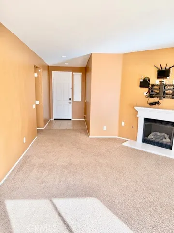 a view of an empty room with a fireplace and a window
