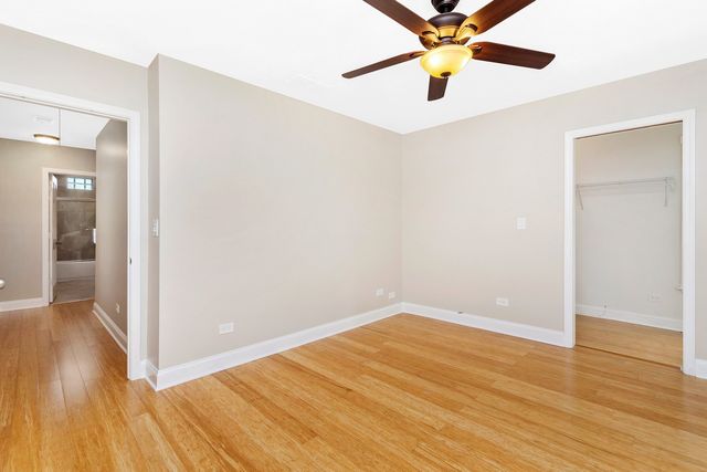 a view of a room with wooden floor and a ceiling fan