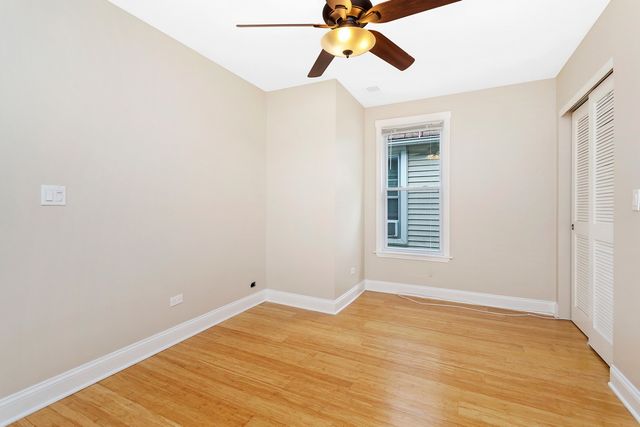 a view of a room with wooden floor and ceiling fan
