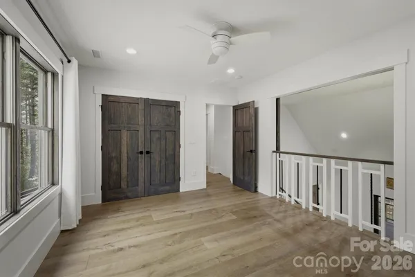 a view of a hallway with wooden floor and staircase