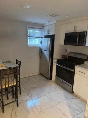 a kitchen with a refrigerator and a stove top oven