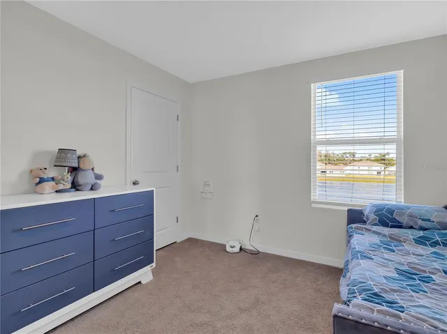 a bedroom with a bed a couch and a large window