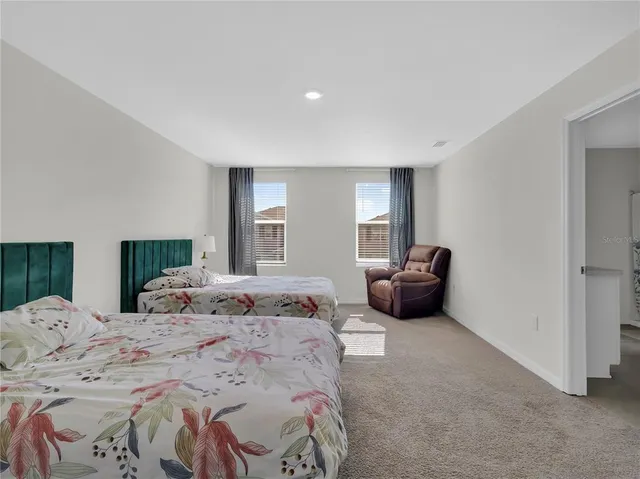 a bedroom with two beds and a chair