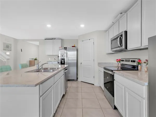 a kitchen with stainless steel appliances granite countertop a sink and a refrigerator