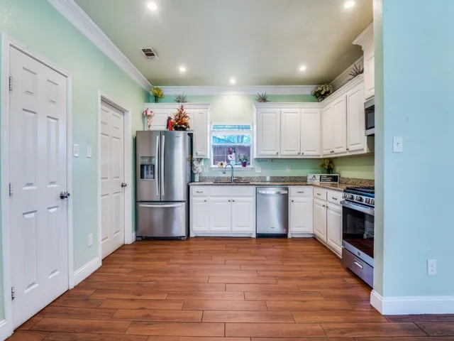 a kitchen with stainless steel appliances a refrigerator sink and cabinets