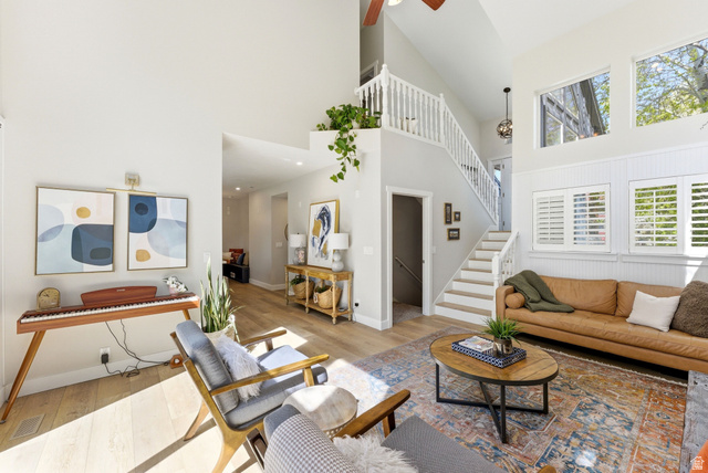7935 Mustang Loop Road Park City, UT 84098 - Photo 11 of 60 Vaulted ceilings with abundant natural light, wood-finish flooring, white plantation shutters, and a prominent staircase with white railings