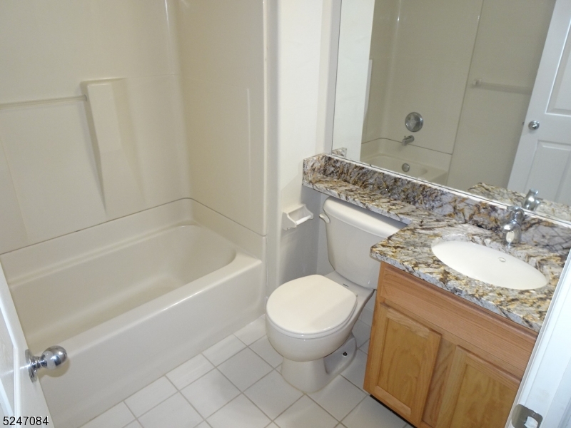 112 Limerick Lane, Unit 1 Phillipsburg, NJ 08865 - Photo 21 of 41 a bathroom with a granite countertop toilet a sink and a bathtub