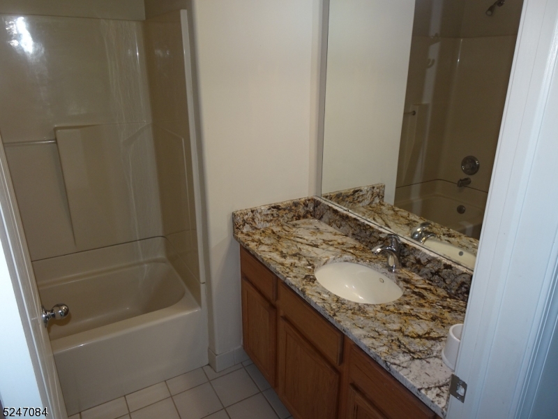 112 Limerick Lane, Unit 1 Phillipsburg, NJ 08865 - Photo 28 of 41 a bathroom with a granite countertop sink a mirror and a bathtub