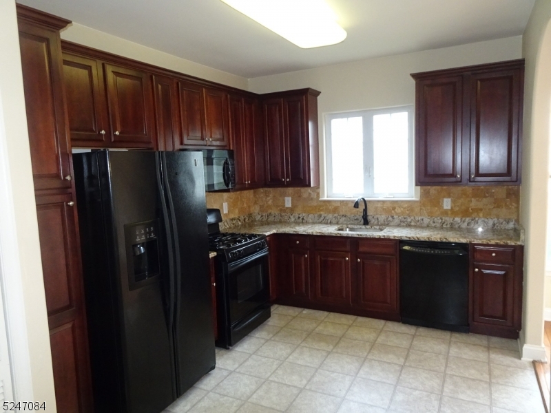 112 Limerick Lane, Unit 1 Phillipsburg, NJ 08865 - Photo 7 of 41 a kitchen with granite countertop wooden cabinets a granite counter and a refrigerator