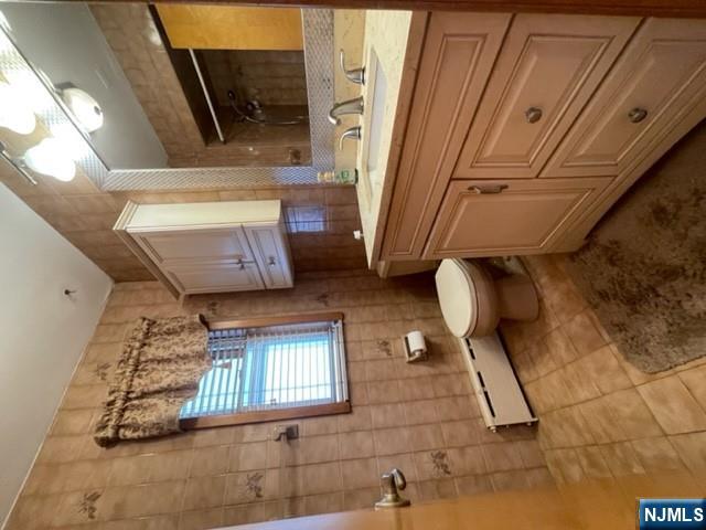 209 8th Street Fairview, NJ 07022 - Photo 11 of 41 a bathroom with a sink a toilet and mirror
