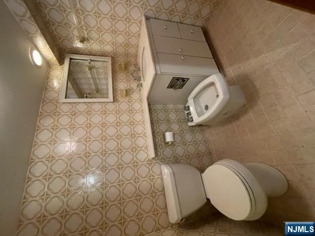 209 8th Street Fairview, NJ 07022 - Photo 16 of 41 a bathroom with a toilet a sink and a mirror