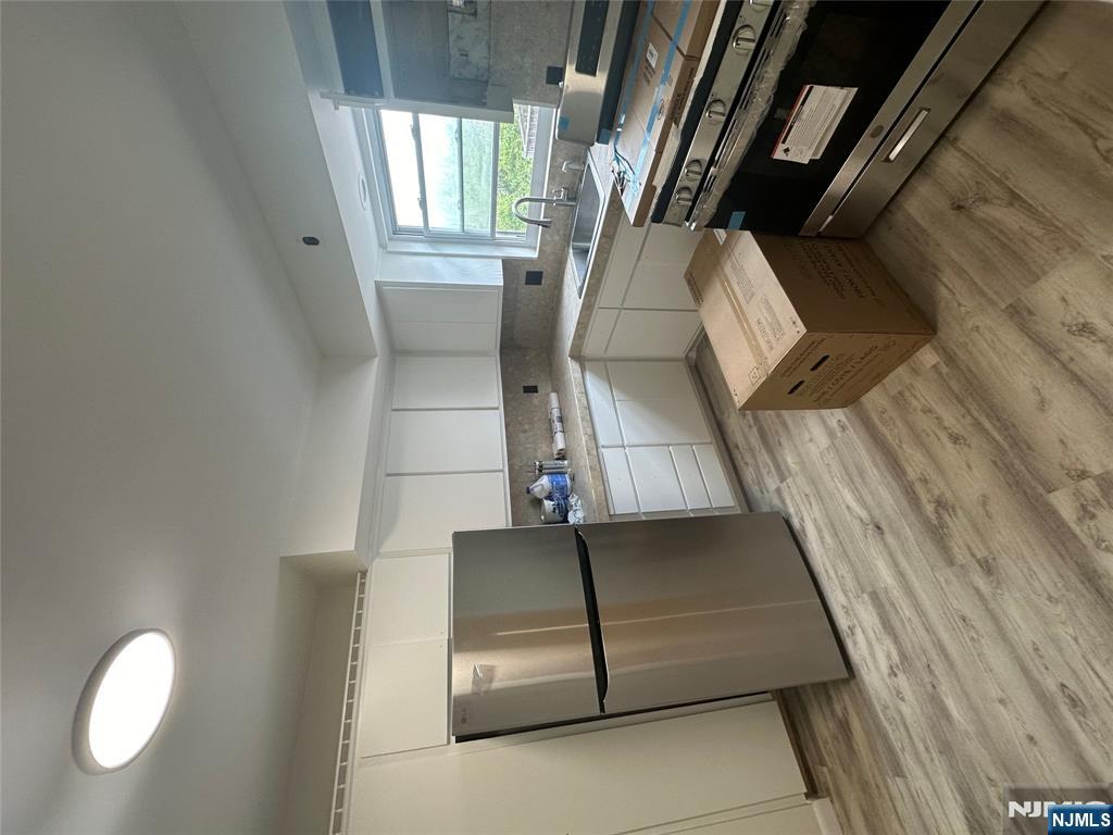 209 8th Street Fairview, NJ 07022 - Photo 34 of 41 a kitchen with wooden floors and white appliances