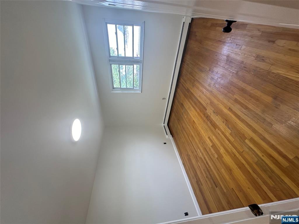 209 8th Street Fairview, NJ 07022 - Photo 39 of 41 an empty room with wooden floor and windows