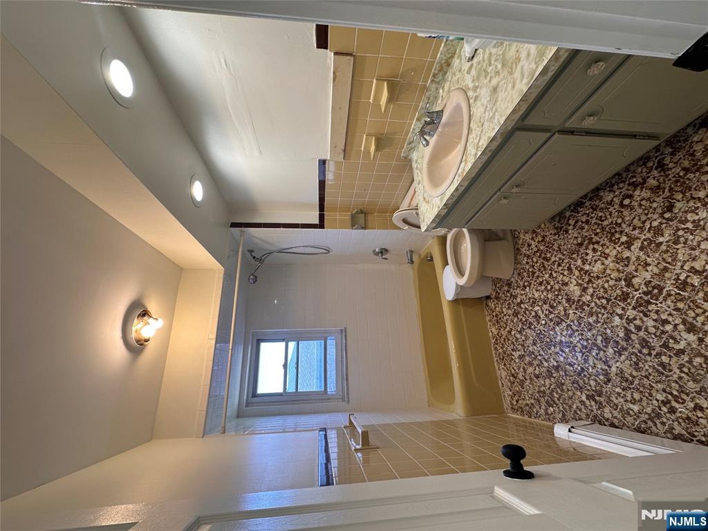 209 8th Street Fairview, NJ 07022 - Photo 40 of 41 a bathroom with a granite countertop sink a toilet and shower