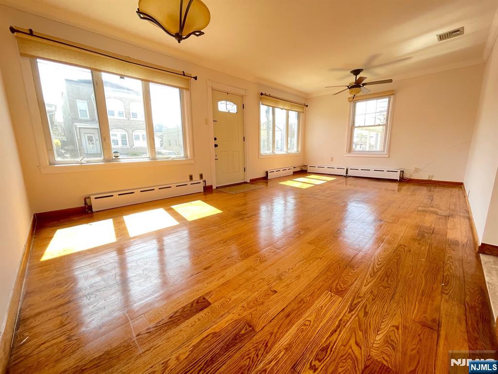 209 8th Street Fairview, NJ 07022 - Photo 5 of 41 a view of empty room with wooden floor and fan
