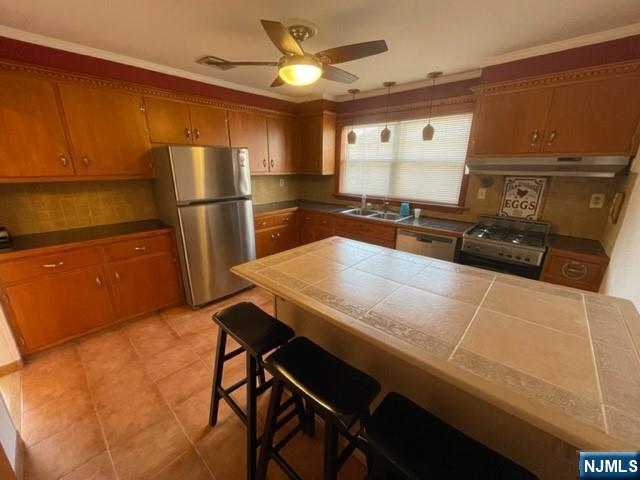209 8th Street Fairview, NJ 07022 - Photo 8 of 41 a kitchen with stainless steel appliances a refrigerator a sink a stove and white cabinets