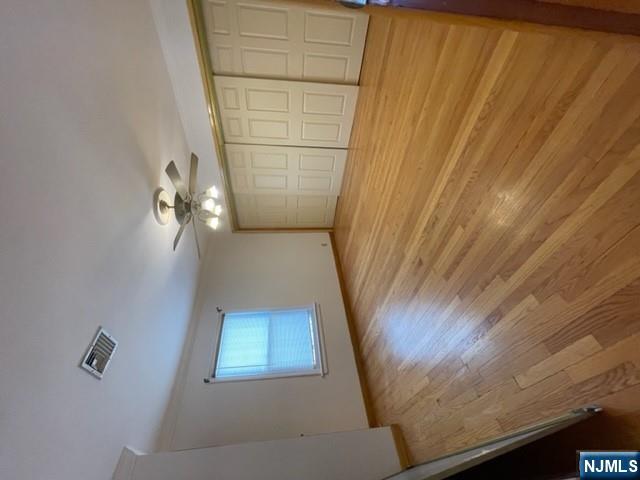 209 8th Street Fairview, NJ 07022 - Photo 9 of 41 an empty room with wooden floor chandelier fan and windows