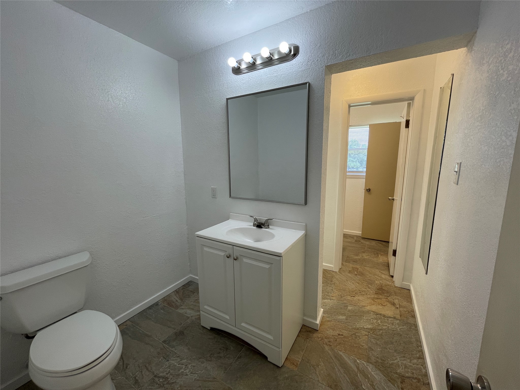 19439 Keenan Cut Off Road Montgomery, TX 77316 - Photo 31 of 39 a bathroom with a granite countertop toilet sink and mirror