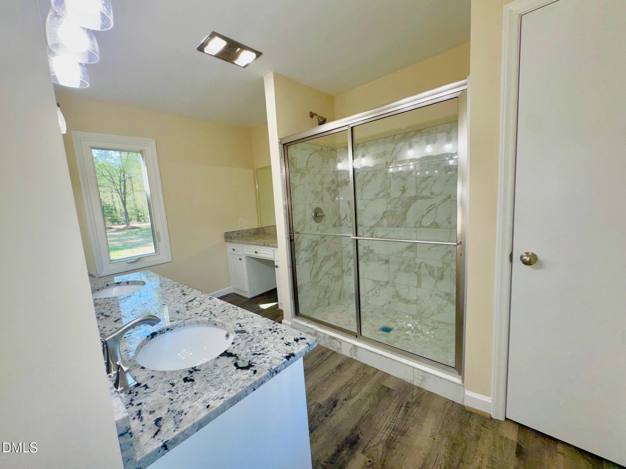 1720 Ross Mill Road Henderson, NC 27537 - Photo 23 of 42 a bathroom with a granite countertop sink a mirror and a shower