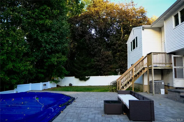 a view of backyard with swimming pool and furniture
