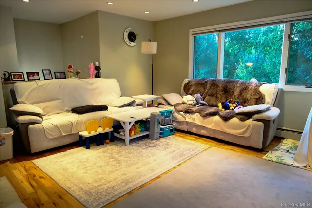 a living room with furniture and a dining table with wooden floor