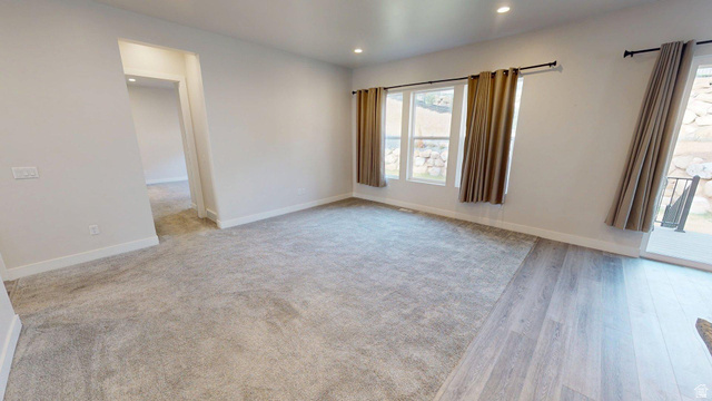 5502 North Valley View Road Lehi, UT 84048 - Photo 9 of 33 Spacious room featuring light gray carpeting and wood-finish flooring