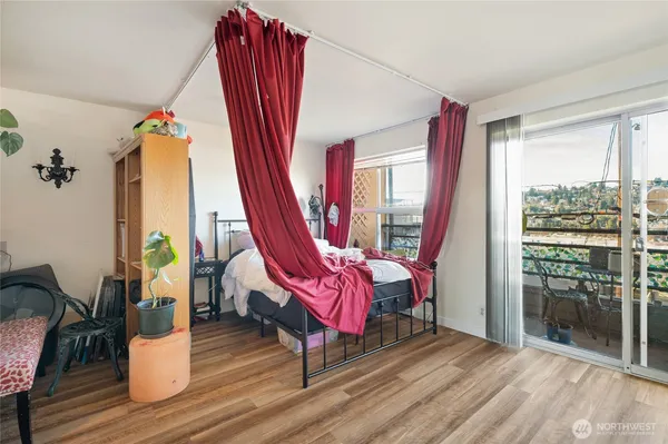 a living room with furniture floor to ceiling window and wooden floor