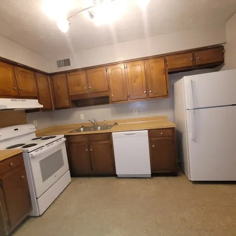 a kitchen with stainless steel appliances granite countertop a refrigerator a sink a stove a microwave a counter and cabinets