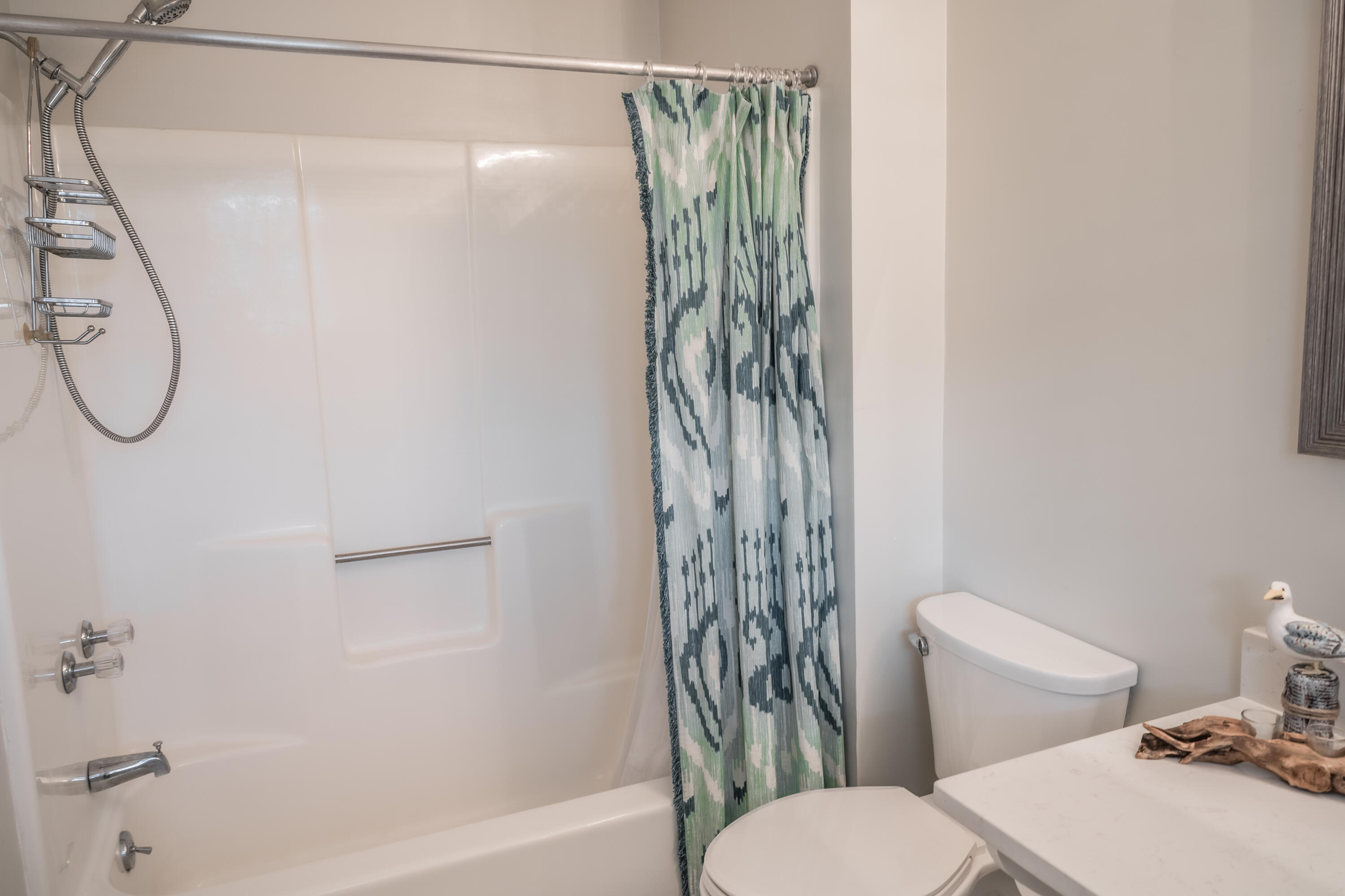 8103 East County Highway 30A Inlet Beach, FL 32461 - Photo 18 of 46 a bathroom with a shower curtain and a toilet next to a window