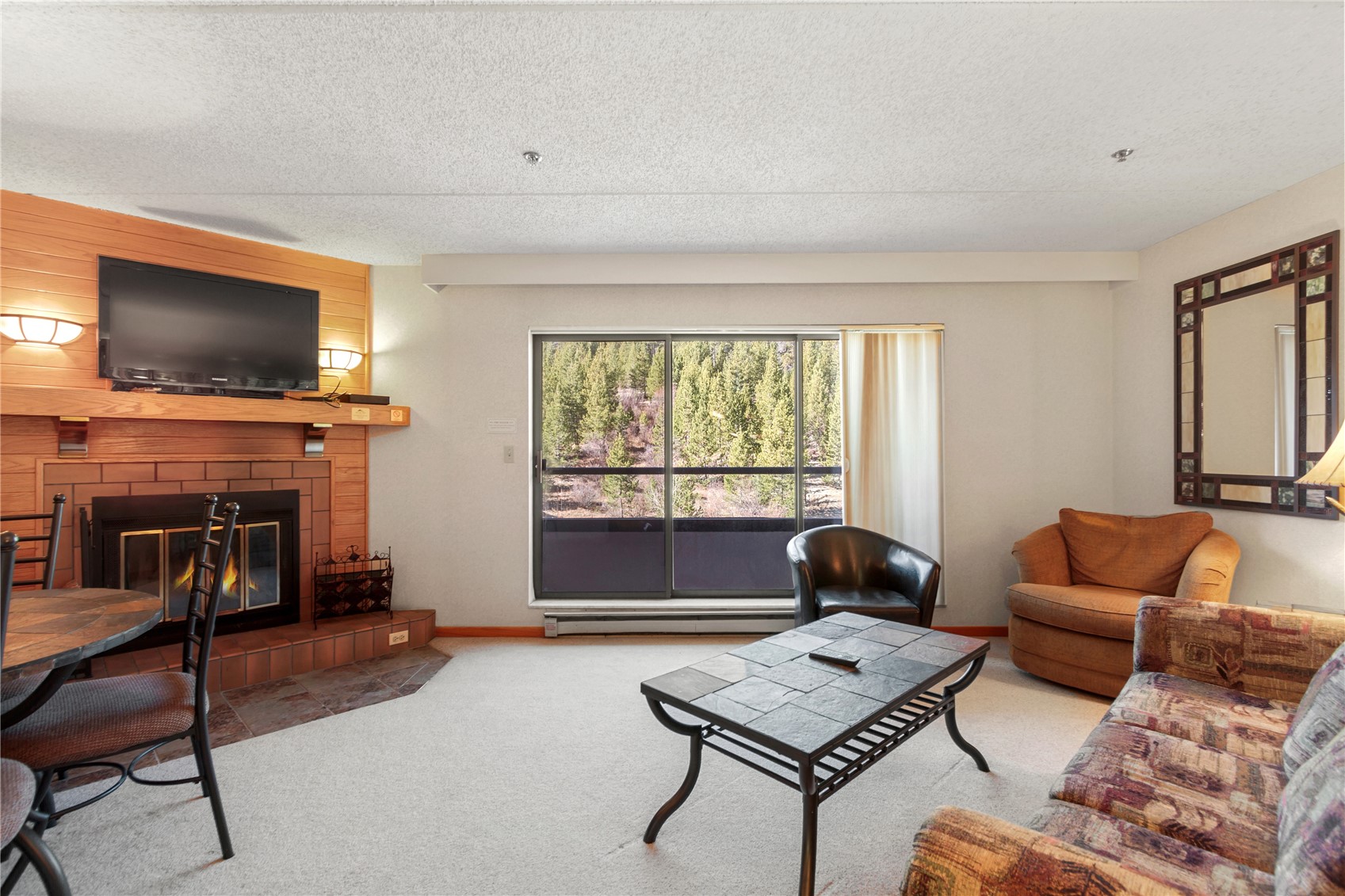 640 Village Road, Unit 4516 Breckenridge, CO 80424 - Photo 2 of 18 Living room featuring carpet, a fireplace, a textured ceiling, and a baseboard heating unit