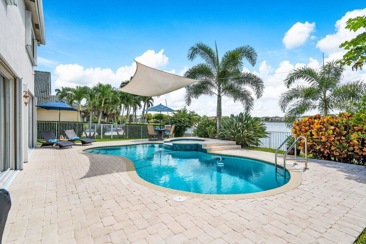 10290 Northwest 60th Place Parkland, FL 33076 - Photo 31 of 36 a view of a swimming pool with a lounge chair
