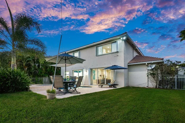 a view of a patio with table and chairs under an umbrella