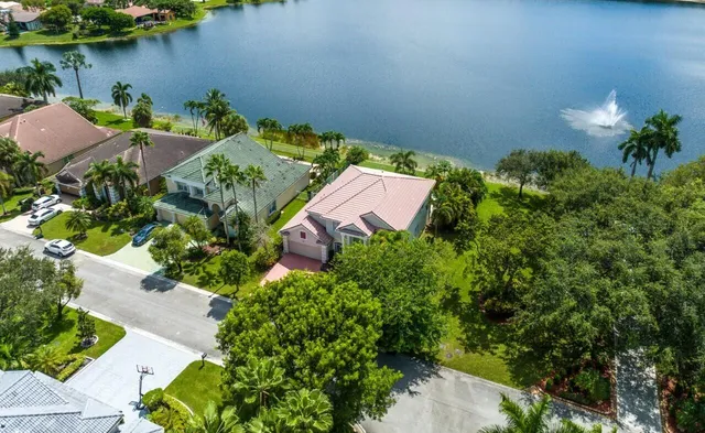 an aerial view of a house with a yard and lake view