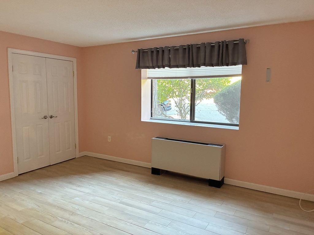 2 Summit Drive, Unit 18 Wakefield, MA 01880 - Photo 4 of 11 an empty room with wooden floor and window