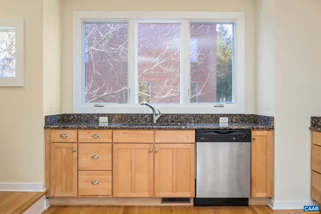 a bathroom with granite countertop a sink and a window