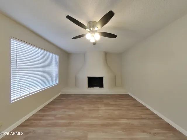 a view of an empty room with a ceiling fan and a window