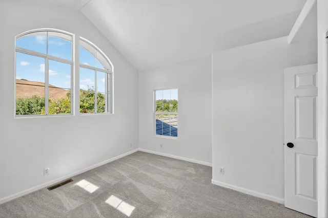 a view of an empty room with glass door and windows