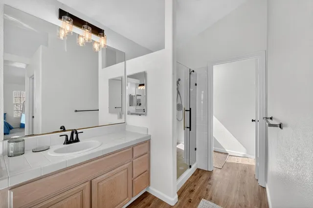 a large white kitchen with granite countertop a large window and a sink