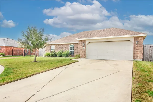 a front view of house with yard and garage