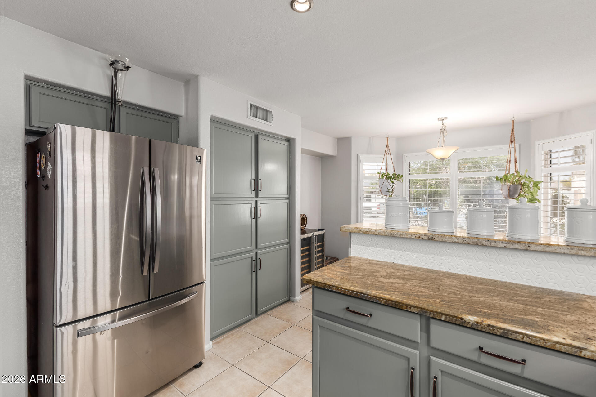 15587 West Rio Vista Lane Goodyear, AZ 85338 - Photo 14 of 36 a kitchen with refrigerator and countertop large window