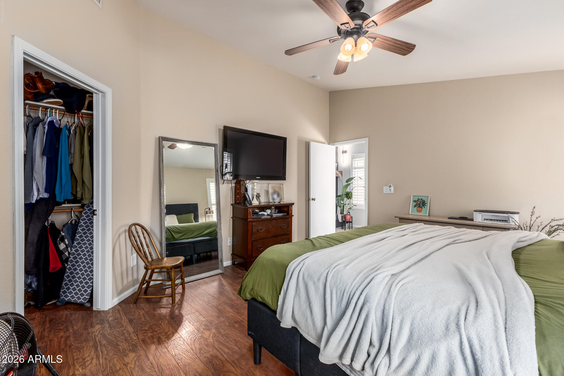15587 West Rio Vista Lane Goodyear, AZ 85338 - Photo 20 of 36 a spacious bedroom with a bed and a chandelier
