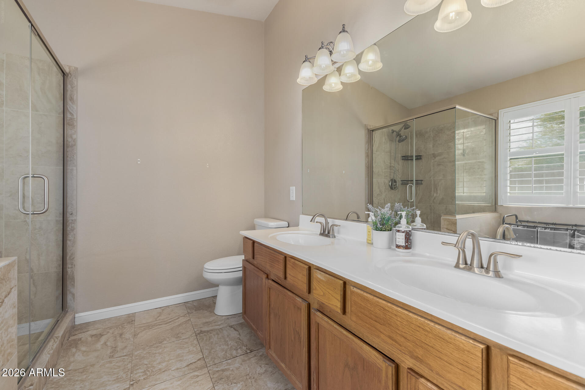 15587 West Rio Vista Lane Goodyear, AZ 85338 - Photo 21 of 36 a bathroom with a double vanity sink toilet and a mirror