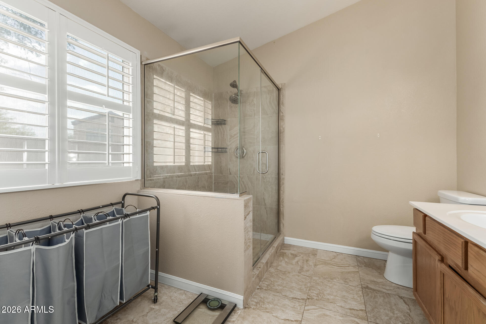 15587 West Rio Vista Lane Goodyear, AZ 85338 - Photo 22 of 36 a bathroom with a granite countertop sink toilet and shower