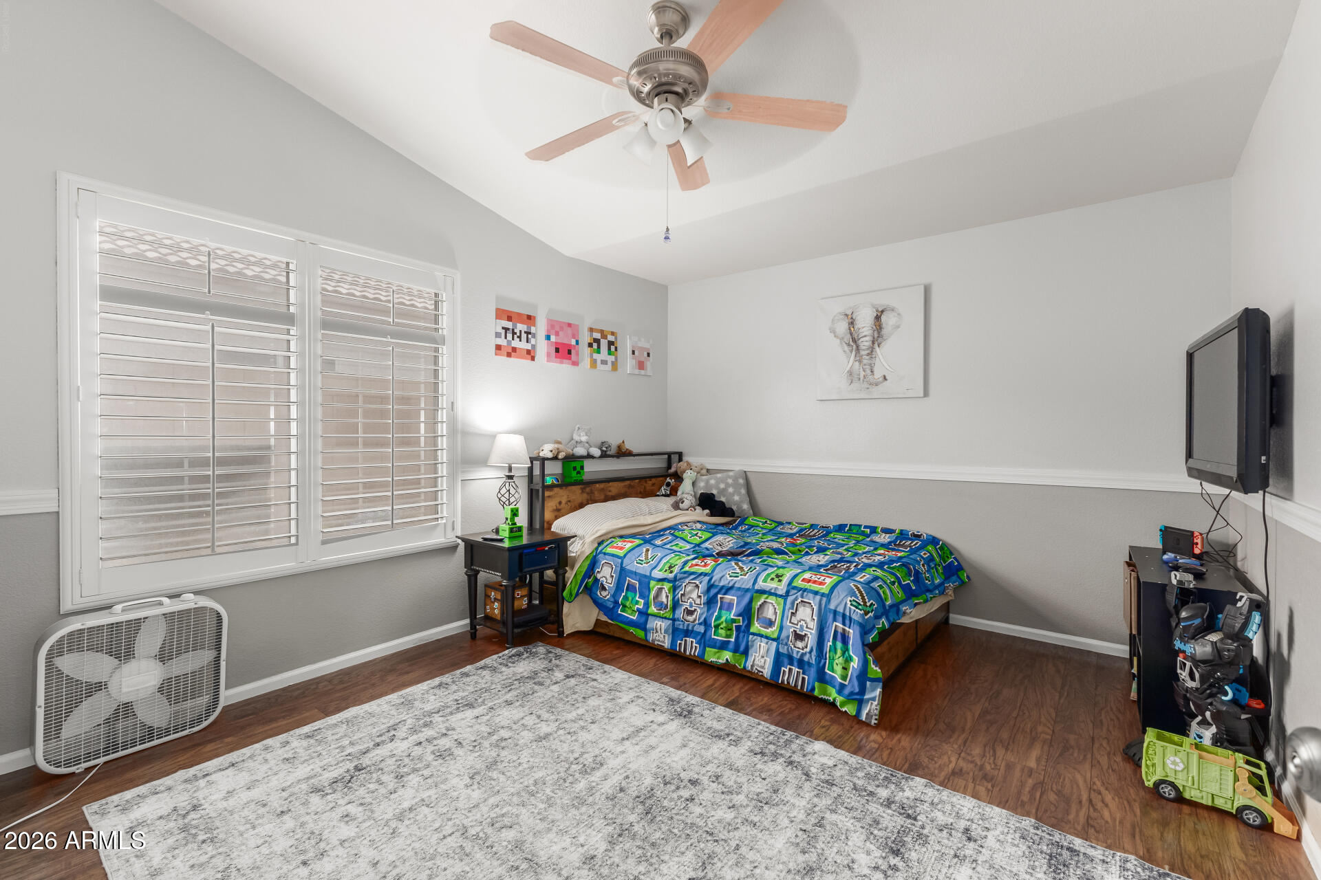 15587 West Rio Vista Lane Goodyear, AZ 85338 - Photo 26 of 36 a bedroom with a bed a chandelier and a window
