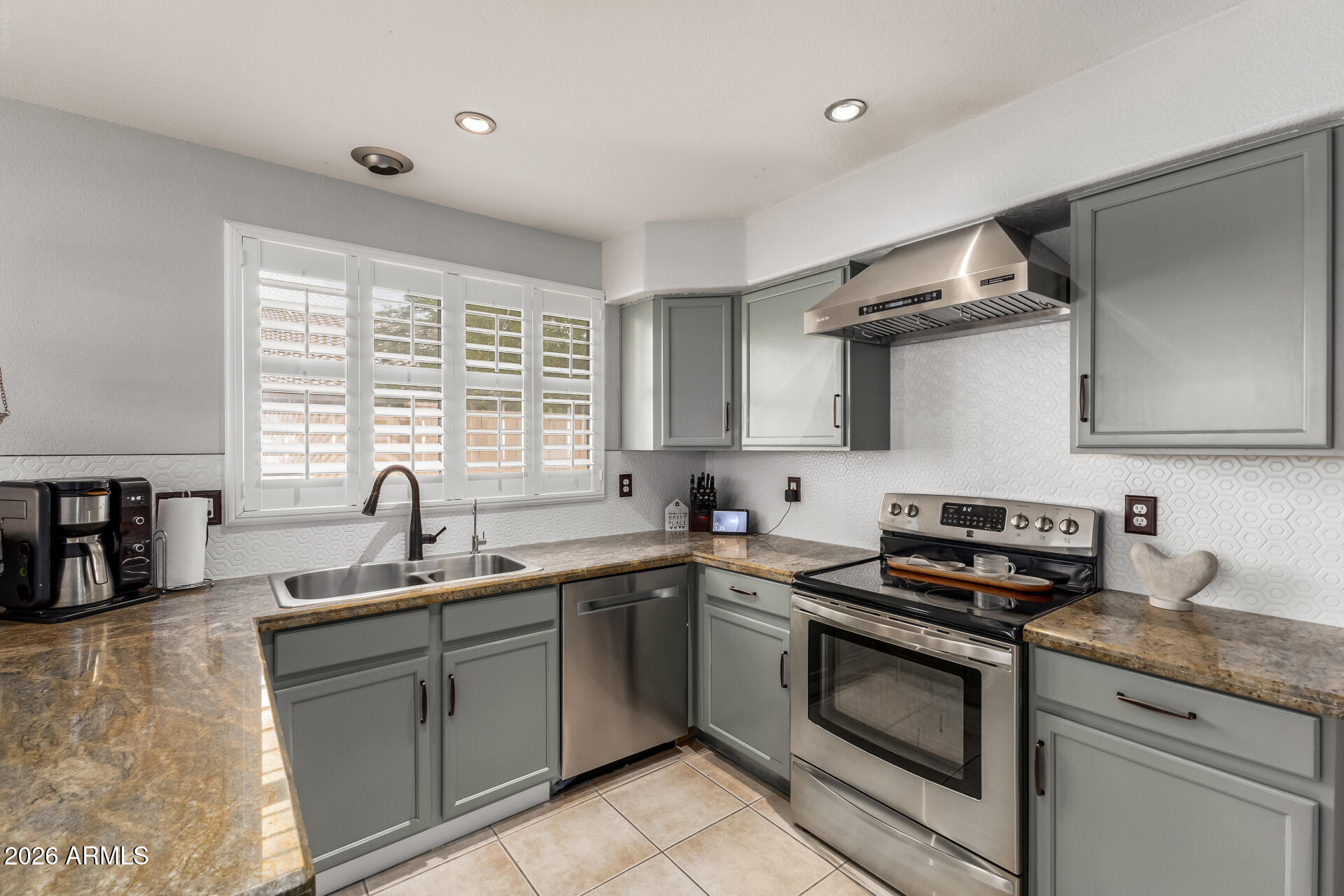 15587 West Rio Vista Lane Goodyear, AZ 85338 - Photo 4 of 36 a kitchen with stainless steel appliances granite countertop a sink stove and cabinets