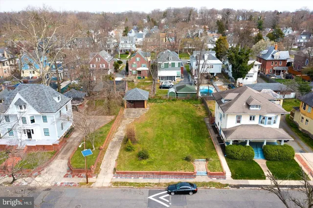 an aerial view of residential houses with outdoor space and street view